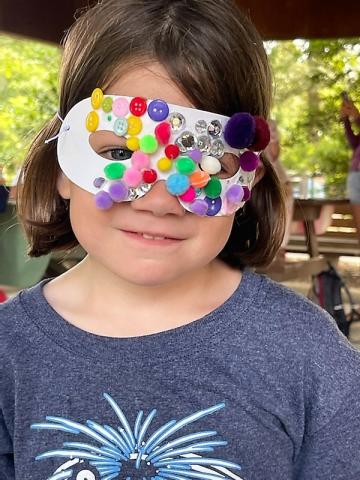 Child with a mask she made at Rehoboth Beach craft activity
